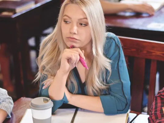 Three older teenager students revising together.