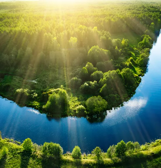 Photo of a winding river surrounded by green fields.