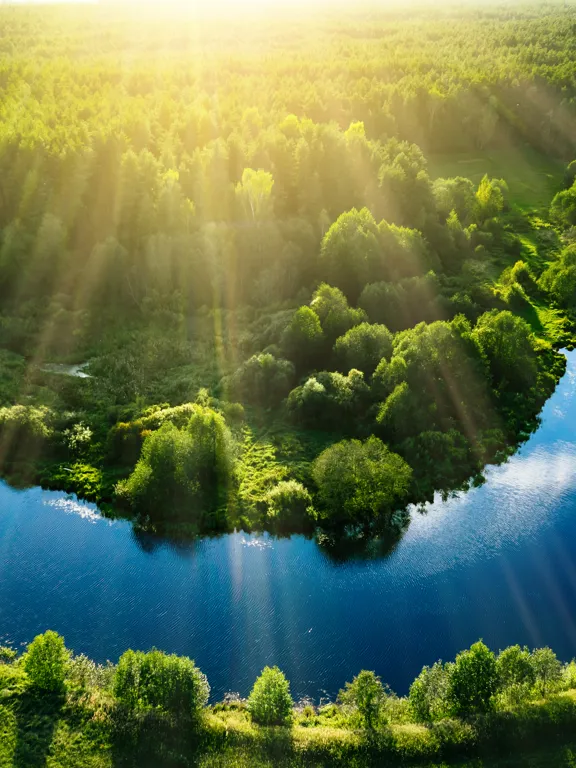 Photo of a winding river surrounded by green fields.