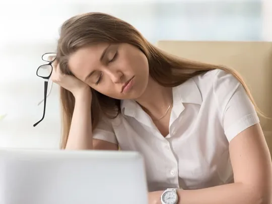 Older teenage girl asleep at her desk.