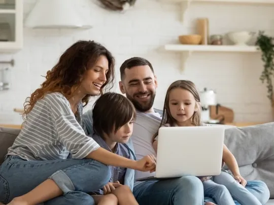 An entire family sat around a laptop.