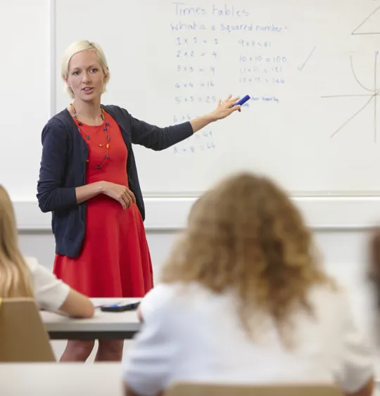 Teacher giving a math lesson to students in classroom.