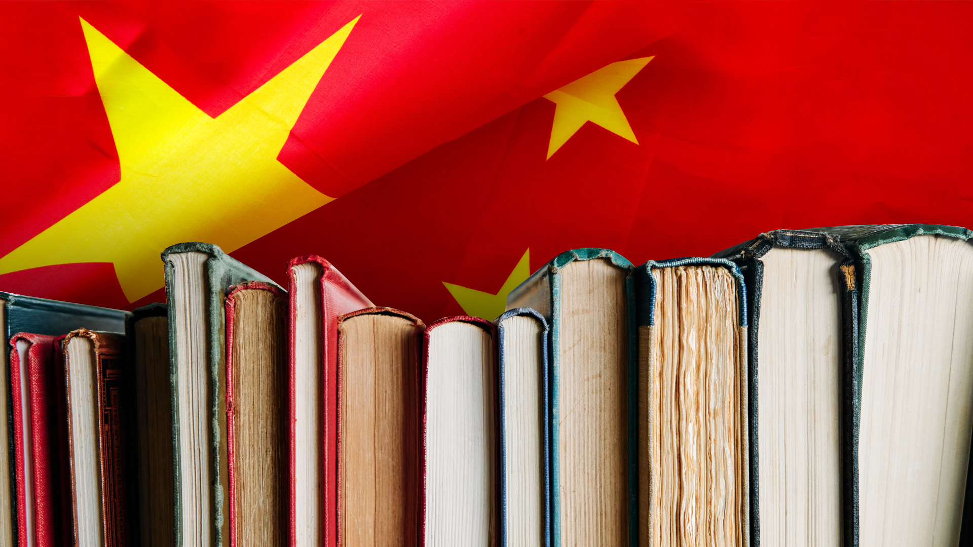 A close-up of a row of books against a vibrant red background of the Chinese flag with yellow stars, symbolizing Mandarin language study.