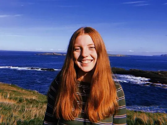 Wolsey Hall Oxford student, Lucy, stood on a cliff over looking the sea.
