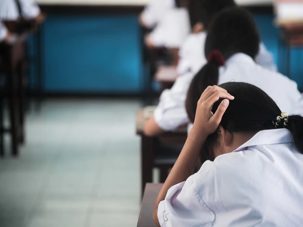 Student in an exam hall, taking an exam. 