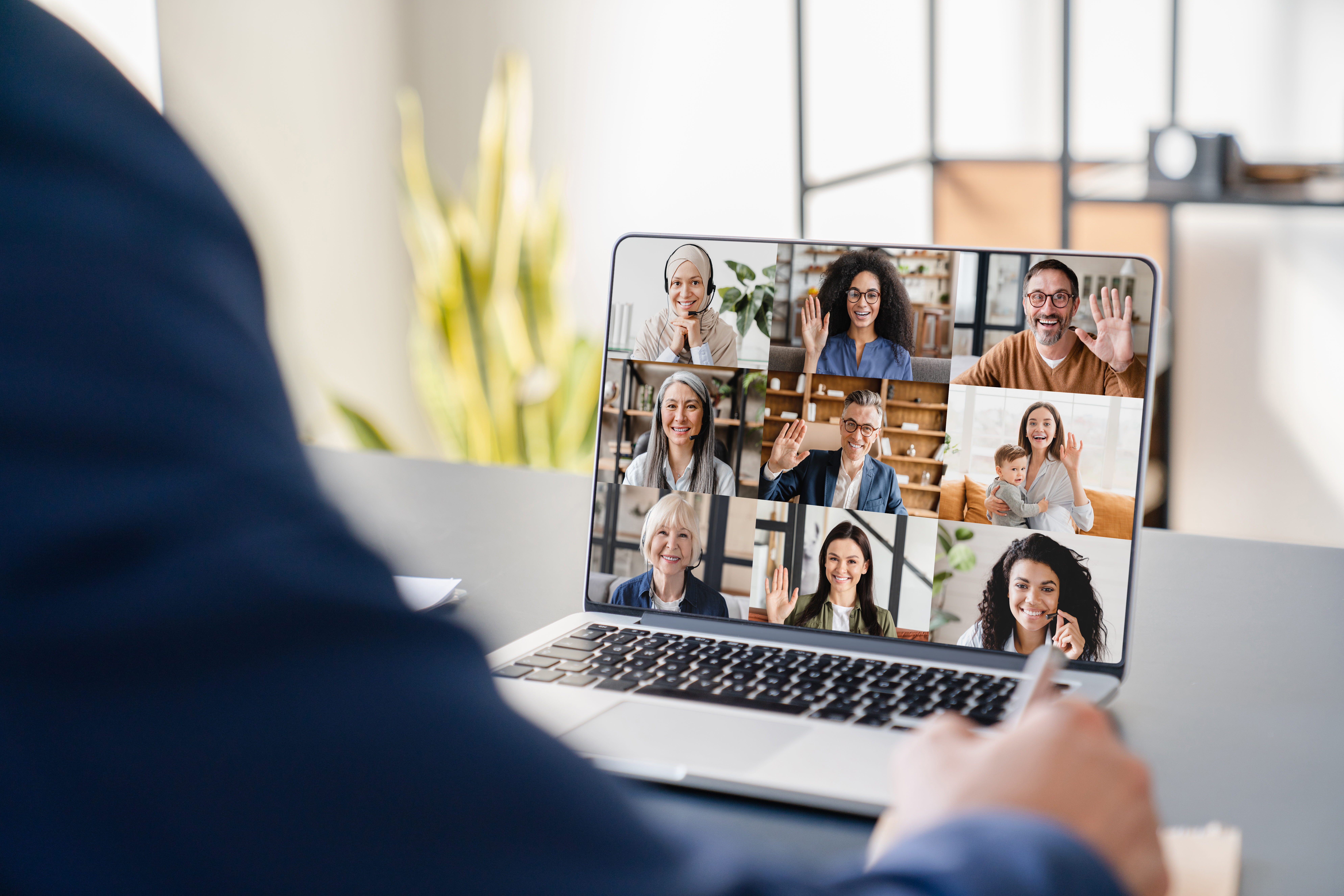 Close up of a laptop screen showing a webinar taking place with multiple people in a call.