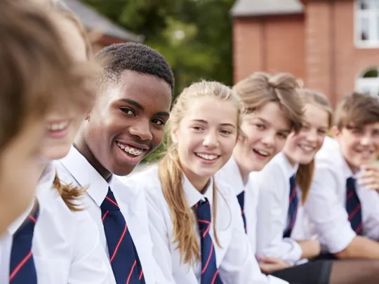 A group of students smiling and socialising.