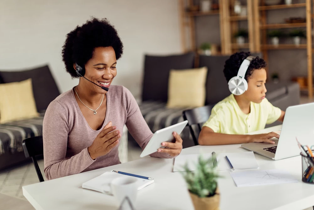 Mother working whilst son is studying close by. 