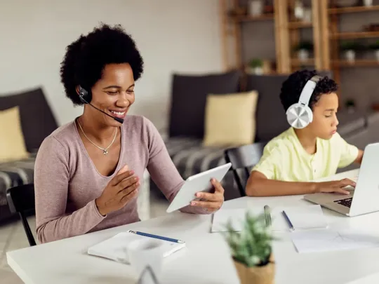 Mother working whilst son is studying close by.