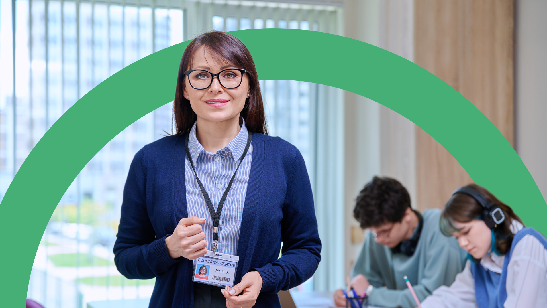 Professional teacher standing in a bright classroom with students blurred in the background