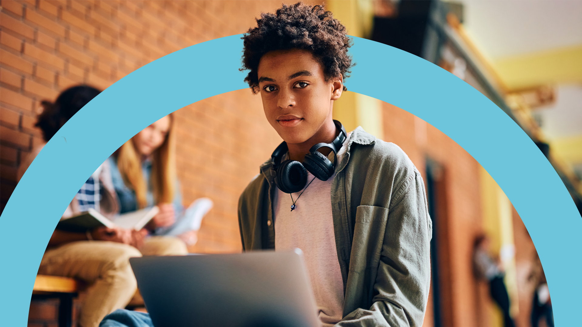 Young student wearing headphones and using a laptop, representing engaging digital learning with Pamoja