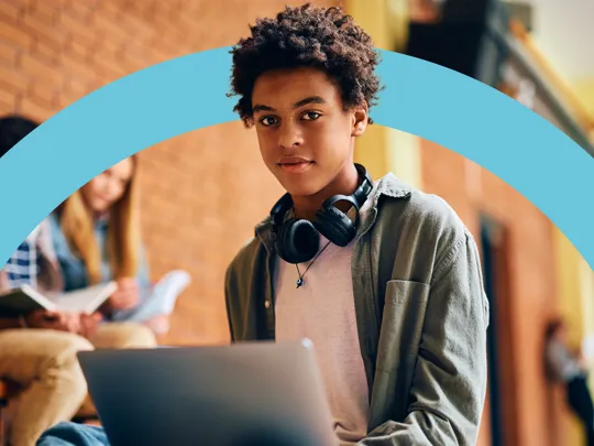 Young student wearing headphones and using a laptop, representing engaging digital learning with Pamoja